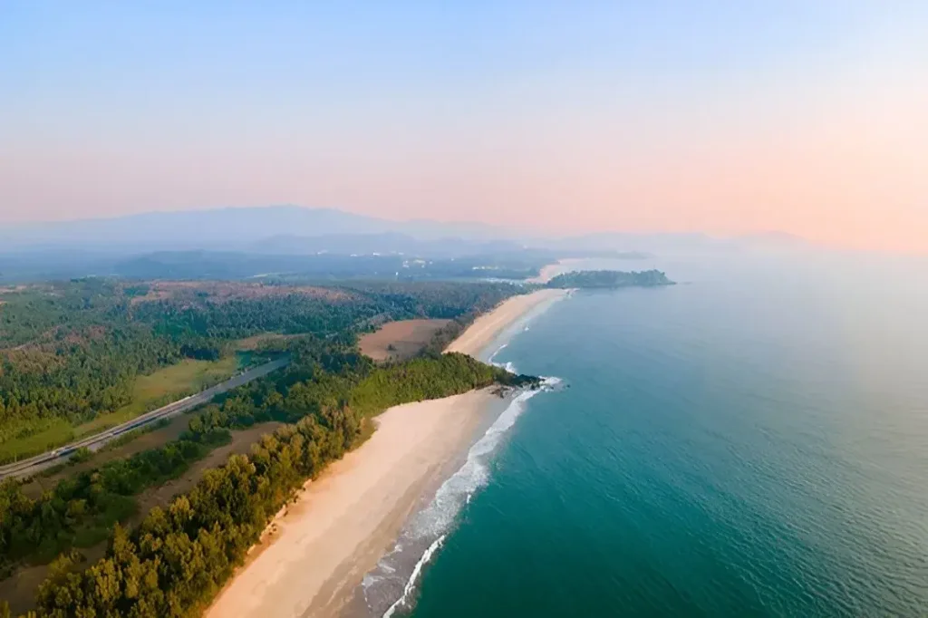 Stunning aerial drone view of Galgibaga Beach coastline in South Goa with green forest and turquoise sea