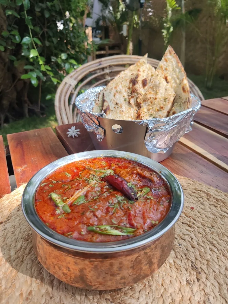 Rich copper bowl of Dal Makhani served alongside warm garlic naan