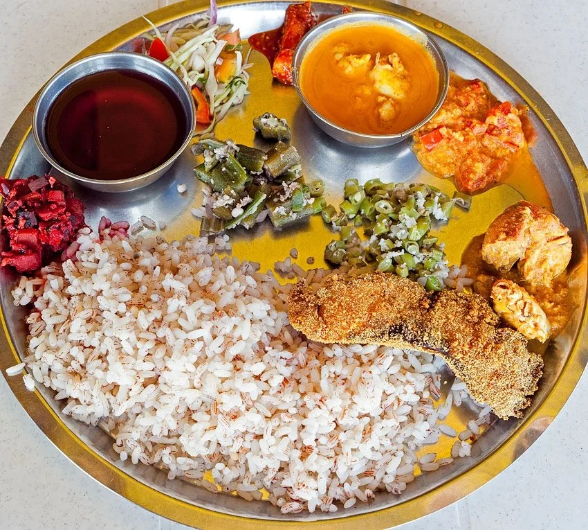 Traditional steel thali featuring local Goan rice, fish, curries, and vegetable sides