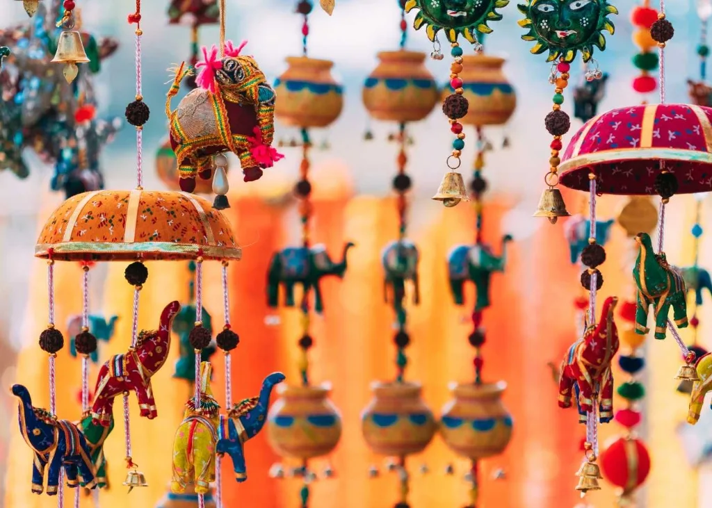 Close-up of vibrant handmade traditional puppets and colorful decorative crafts hanging at a market