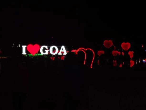 Neon sign displaying I love Goa glowing red at night