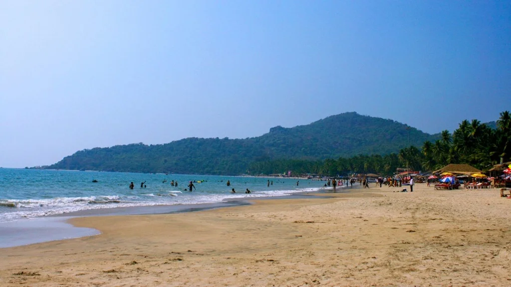 Panoramic view of Palolem Beach shoreline with tourists enjoying the sand and sea