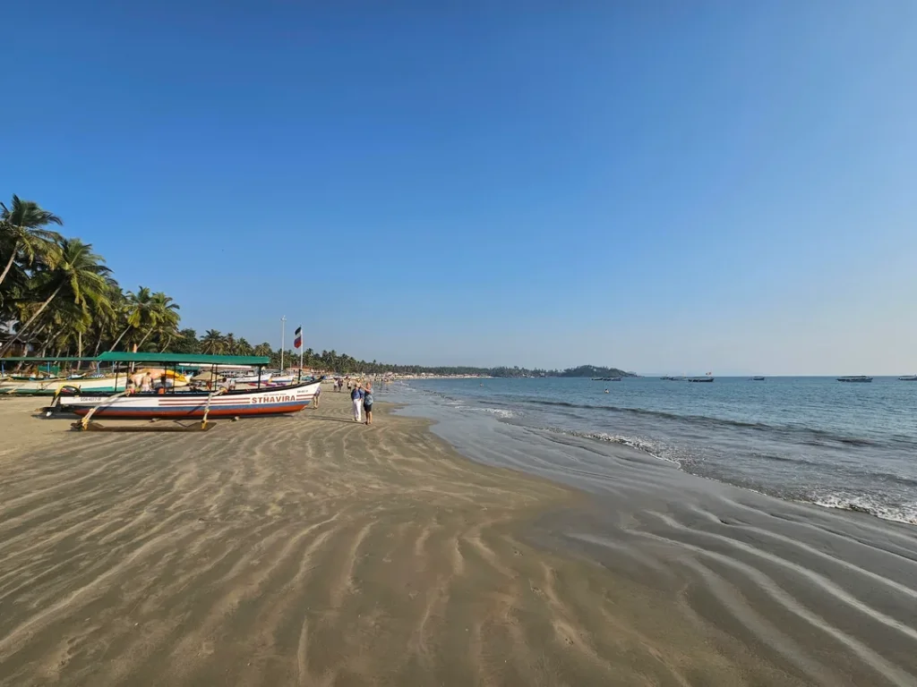 Traditional Goan fishing boat parked on the wide sandy beachline of Agonda Beach
